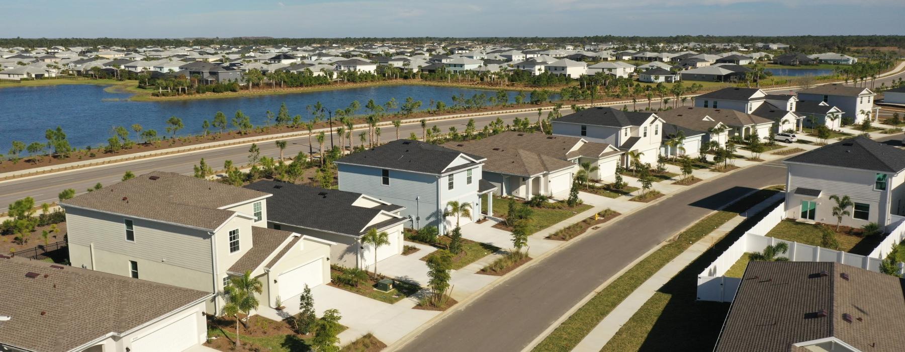 street flanked by homes near the lake at The Flatwoods at Babcock Ranch